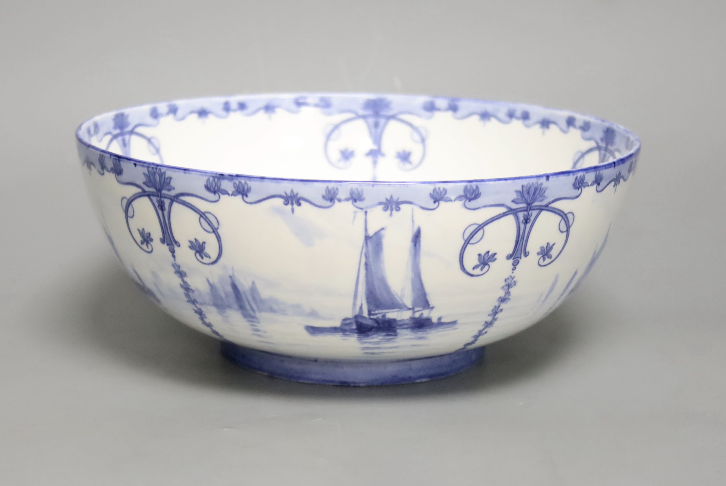 A Royal Crown Derby blue and white bowl painted with sailing scenes, by W.E.J. Dean, diameter 23cm